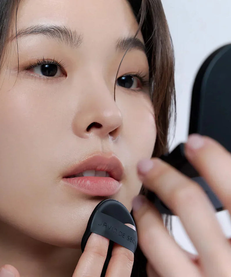 Woman applying JAVIN DE SEOUL Wink Cushion Mat Pocket 8g with a makeup puff