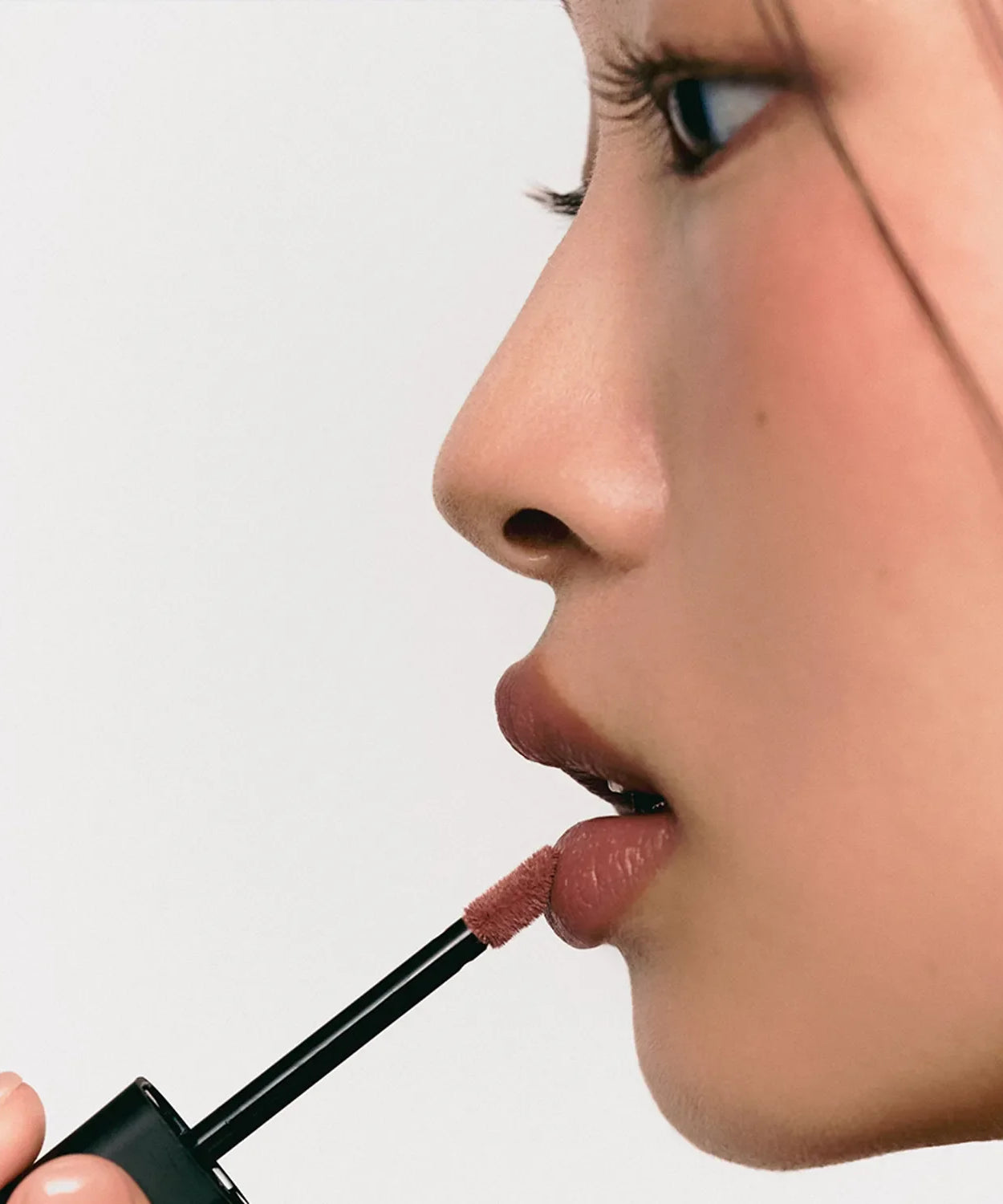 Woman applying JAVIN DE SEOUL Wink Lip Shade Primer with applicator