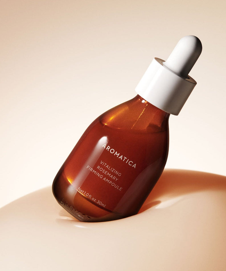 Bottle of AROMATICA Vitalizing Rosemary Elasticity Ampoule 30ML against a soft background.