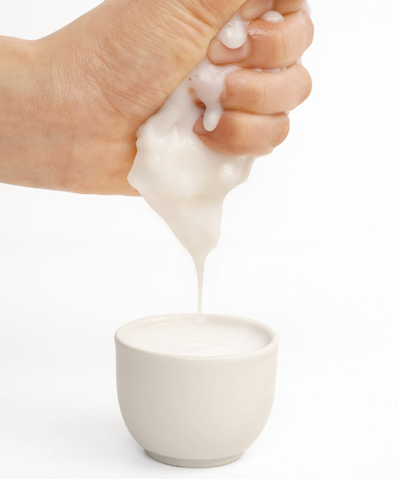 BARULAB Rice Makgeolli Probiotic Yeast Cream In Mask 5 Sheets being squeezed into a white cup.