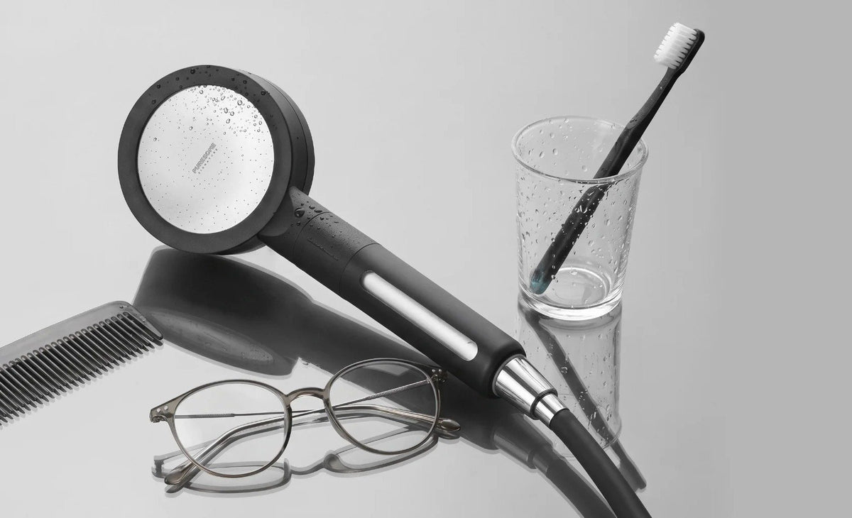 BODYLUV Puresome shower head next to a glass with a toothbrush