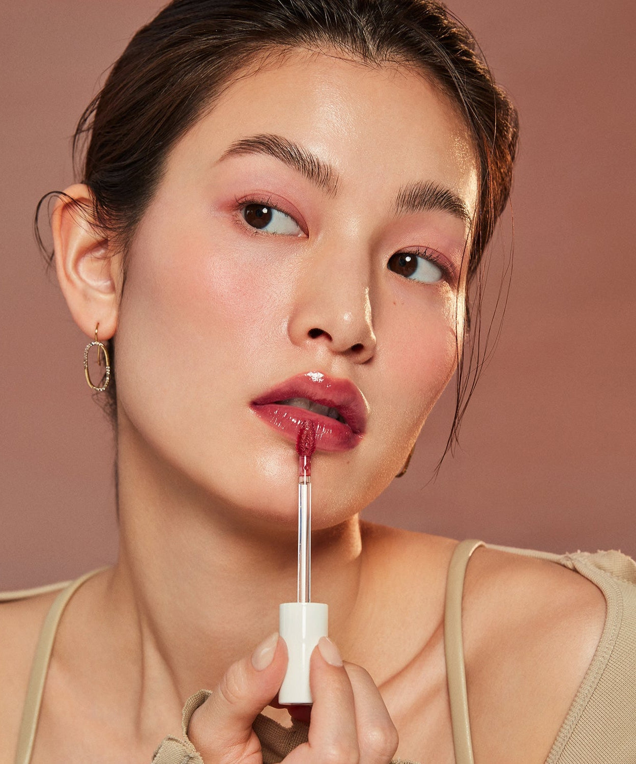 Woman applying HINCE Mood Enhancer Water Liquid Glow to lips