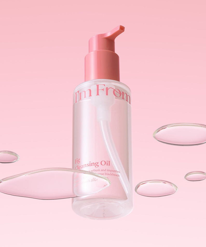 I'M FROM Fig Cleansing Oil 200ml bottle with floating oil drops on pink background.