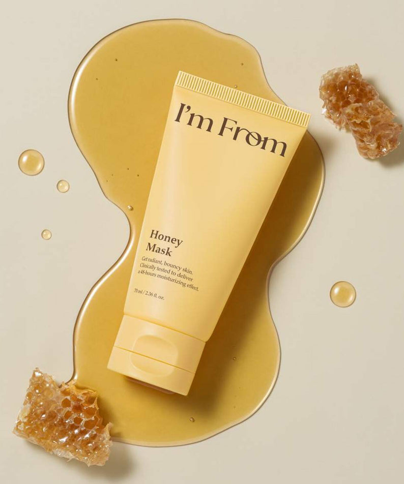 I'M FROM Honey Mask 70ml in yellow tube surrounded by honeycomb and honey on beige background, skincare product for nourishing skin.