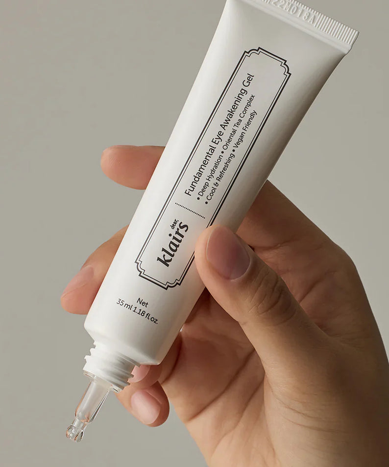 Hand holding KLAIRS Fundamental Eye Awakening Gel 35ml tube against a neutral background.