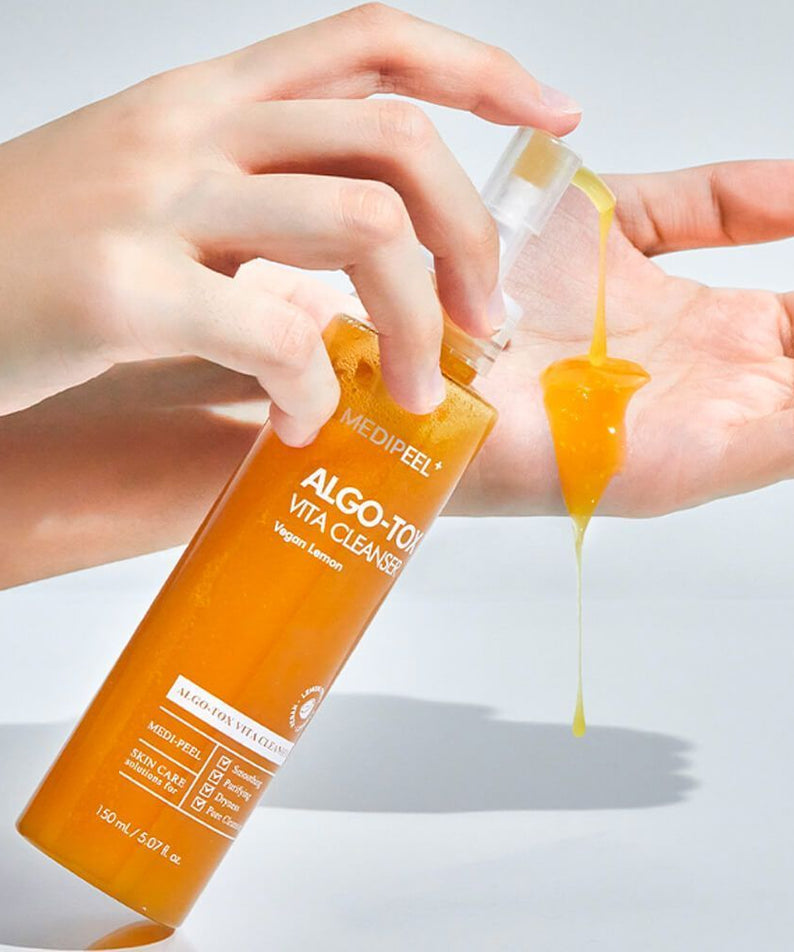 Hand applying MEDIPEEL Algo Tox Vita Cleanser 150ml to skin, showing texture and consistency of the skincare product.