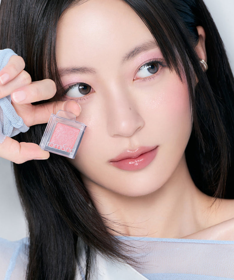 Woman showcasing ROMAND Slide In Single makeup product.
