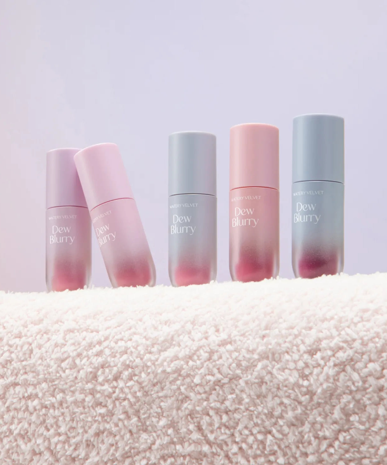 TOO COOL FOR SCHOOL Dew Blurry Tint collection displayed on a soft textured surface, featuring various shades of the product.
