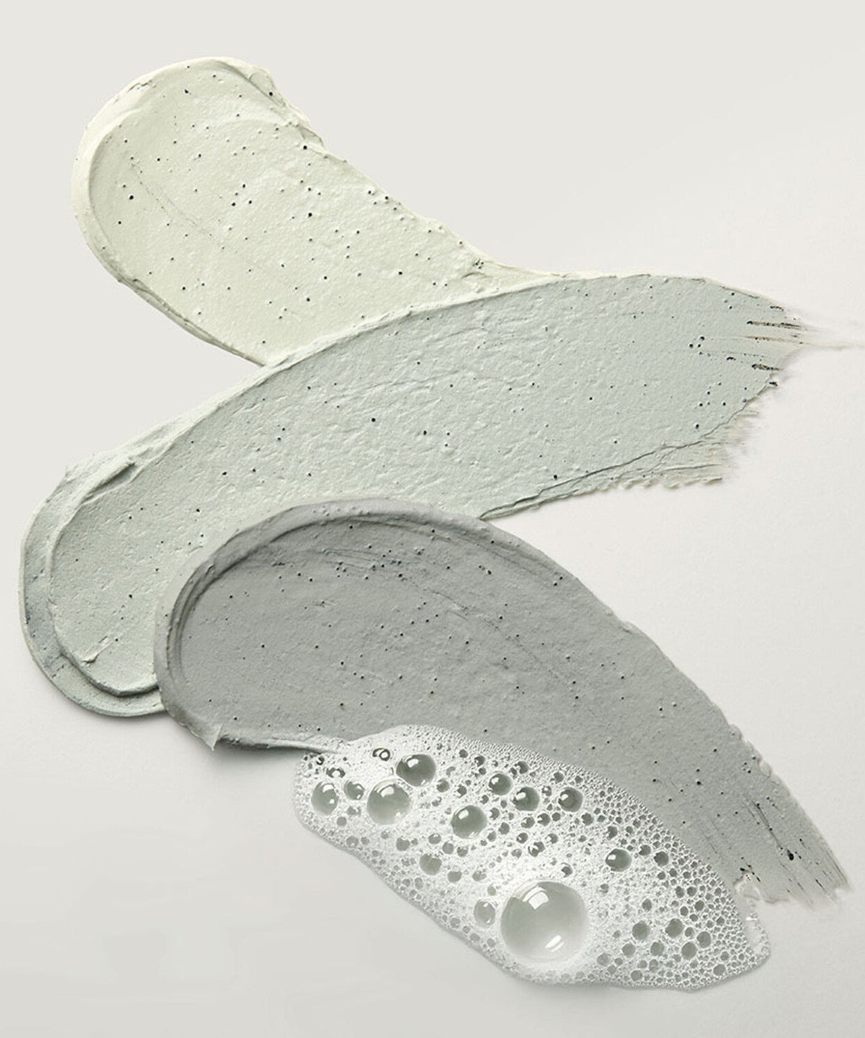 Texture swatches of WHIPPED Mugtree Vegan Cookie Clay Pack Cleanser 180ml, showcasing natural clay and foaming formula.