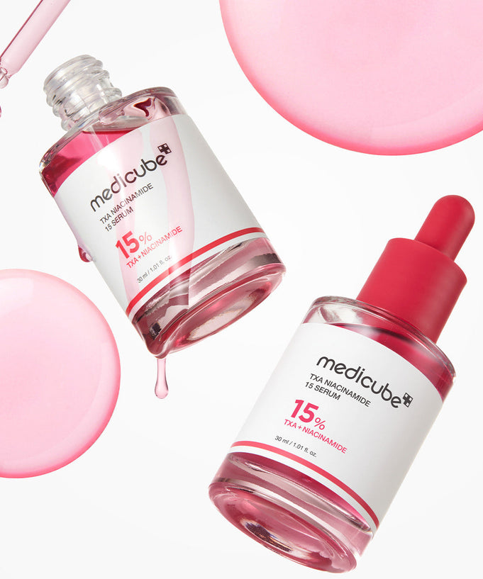 Image of MEDICUBE TXA Trace Toning Serum 30ml bottles and droplets, highlighting the skincare product.