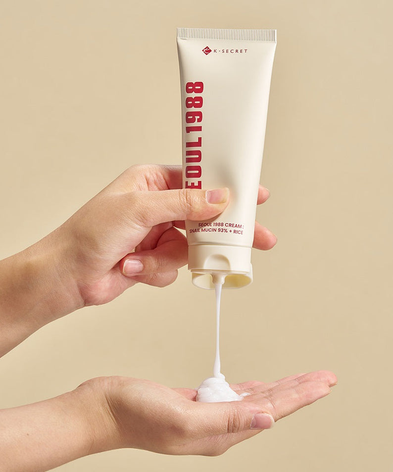 SEOUL 1988 Snail 93 Cream being applied from tube onto hand against neutral background