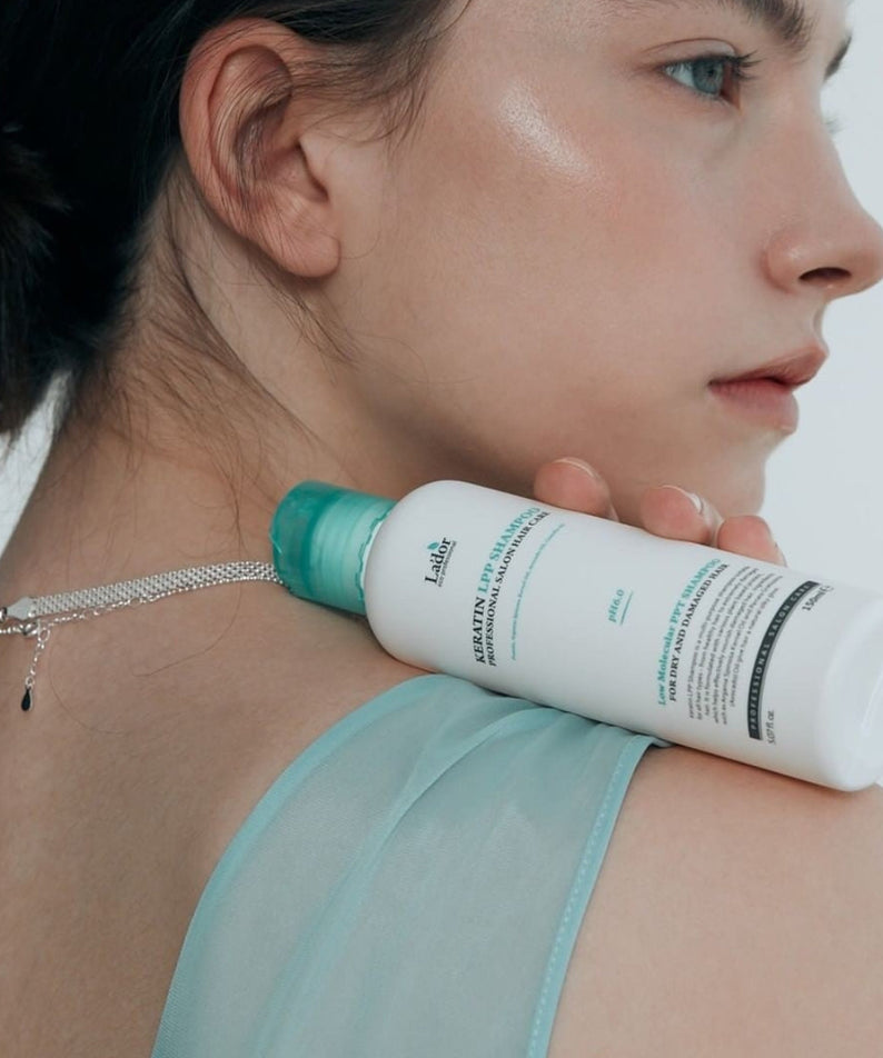 Woman holding LADOR Keratin LPP Protein Shampoo 150ml on shoulder