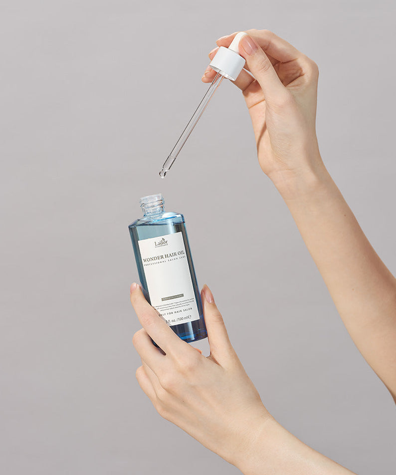 LADOR Wonder Hair Moisture Oil 100ml bottle and dropper for nourishing hair care.