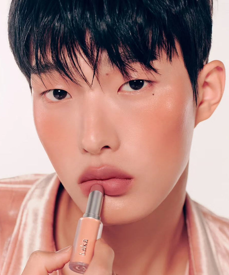 Person applying LAKA Bulky Matte Lipstick to lips, showcasing the product's rich, matte finish.