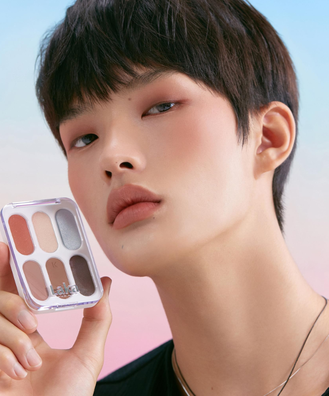 Model holding LAKA Forever 6 Eye Palette against colorful backdrop