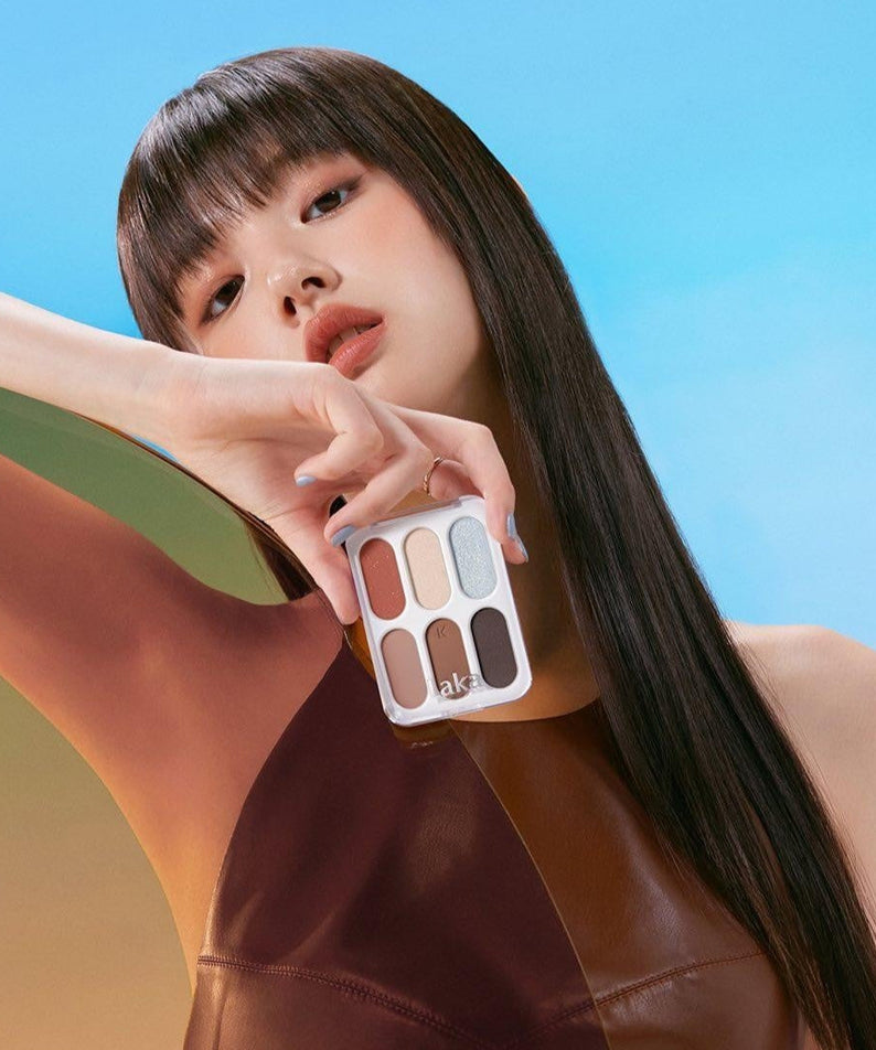 Model holding LAKA Forever 6 Eye Palette against a colorful background.
