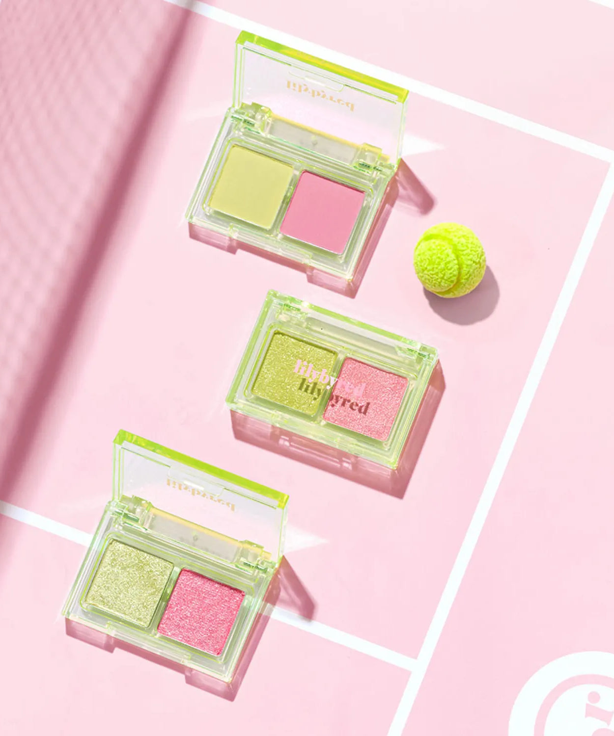 LILYBYRED Little Bitty Moment Shadow with vibrant eye shadow shades on a pink background with a green tennis ball.