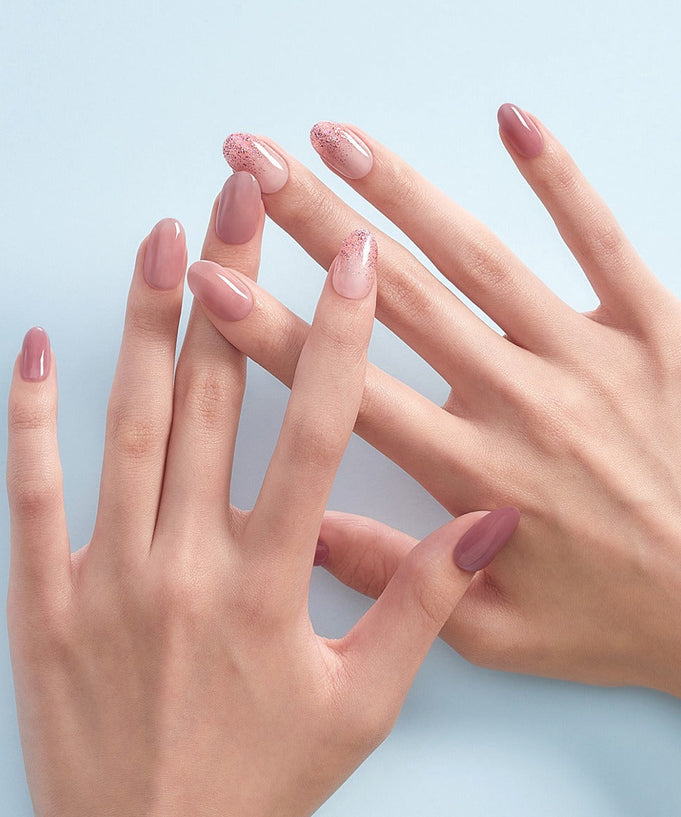 Elegant nails showcasing DASHING DIVA MAGIC PRESS Lovely Muse - Long Oval in soft pink hues on a pale blue background.