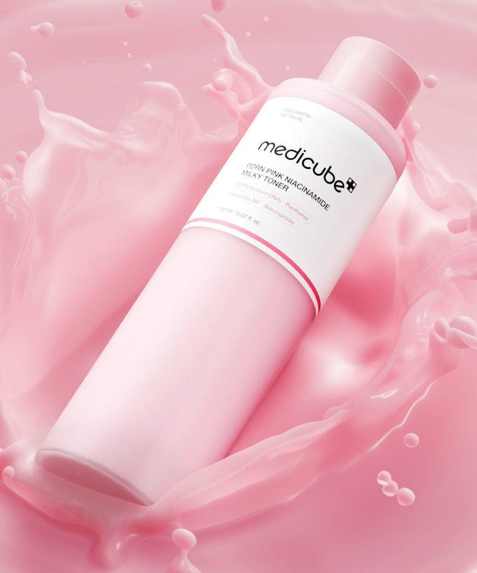 MEDICUBE PDRN Milky Toner Essence 150ml bottle surrounded by pink splash background