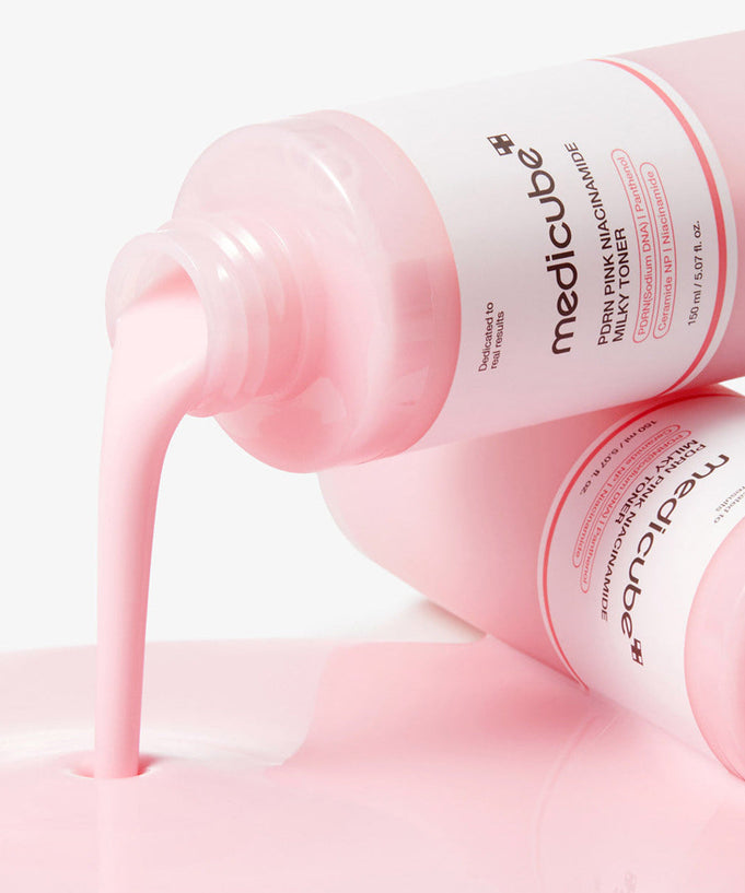 MEDICUBE PDRN Milky Toner Essence 150ml pouring from the bottle, showcasing the texture and color of the skincare product.