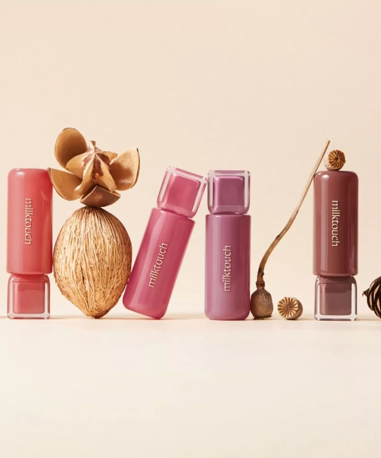 MILK TOUCH Jelly Fit Tinted Glow Tint products displayed with natural elements like pinecones and dried flowers.