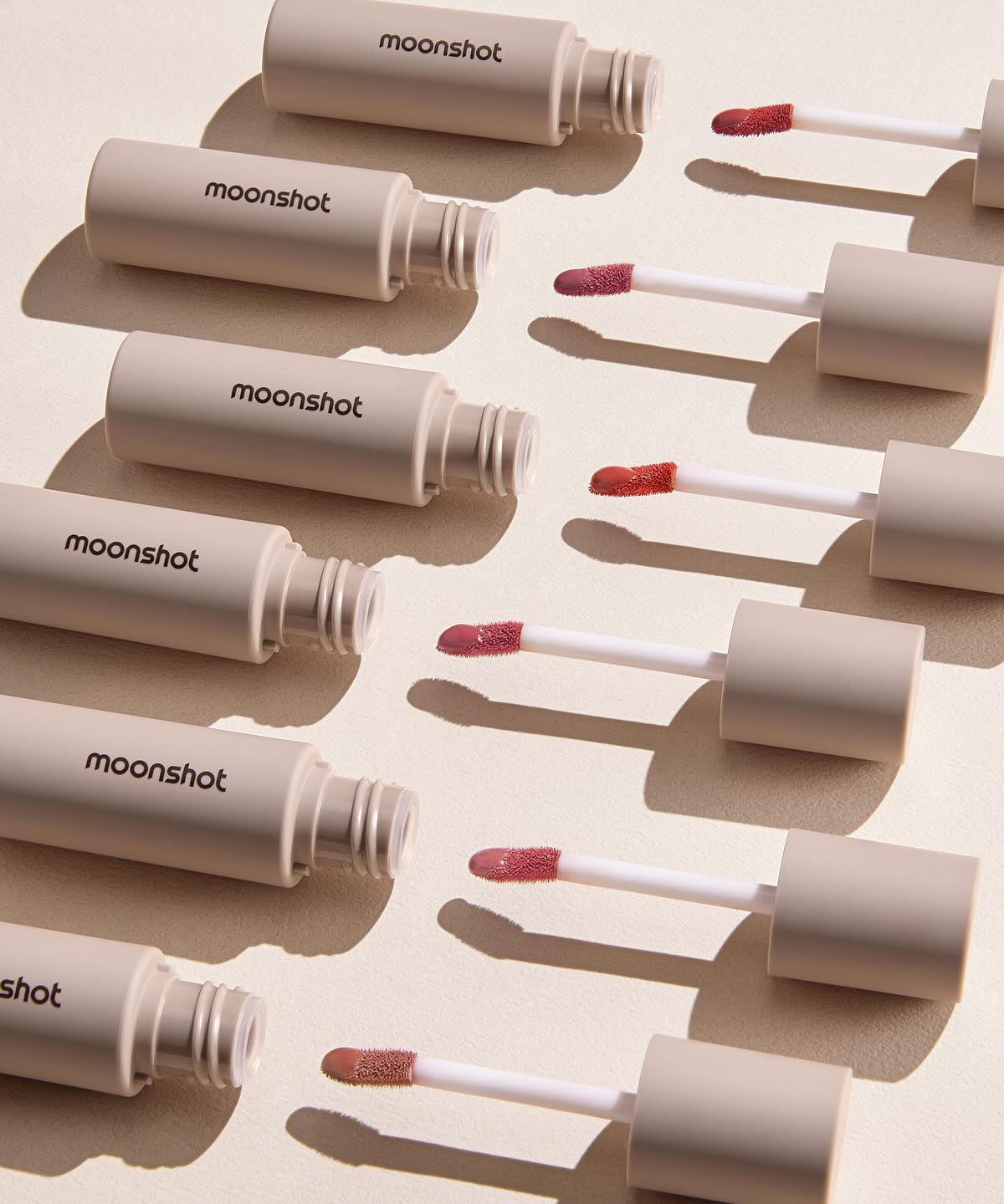 MOONSHOT Conscious Fit Melow Lip Tint tubes displayed with applicators.