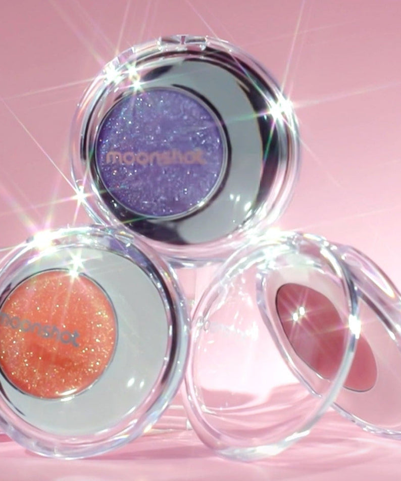 MOONSHOT Melting Mood Lip & Cheek products showcase with vibrant colors and sparkle against a pink background.