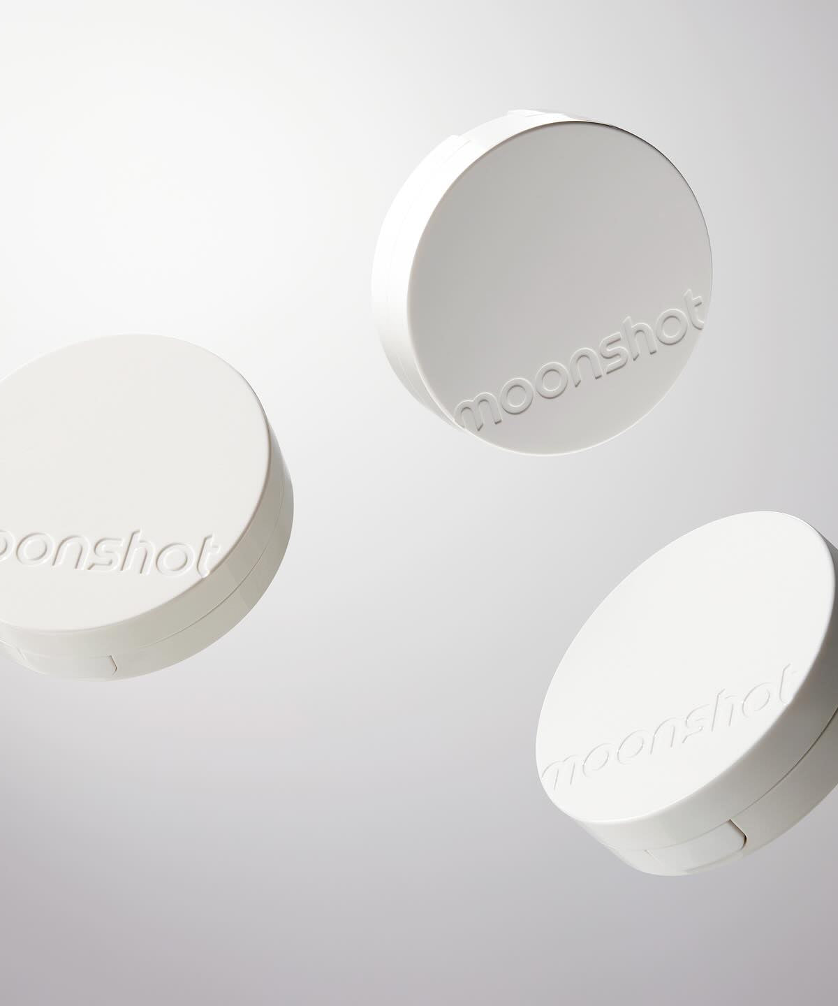 Image of three white cases of MOONSHOT Conscious Fit Glow Cushion Foundation.