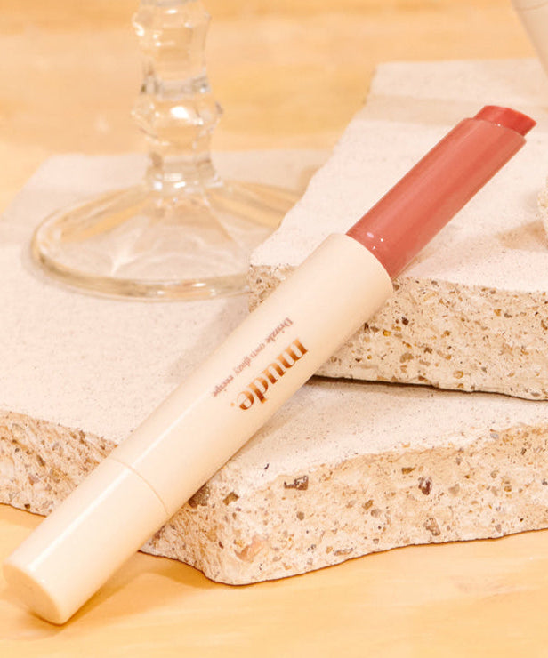 MUDE Drizzle Night lip product on stone surface