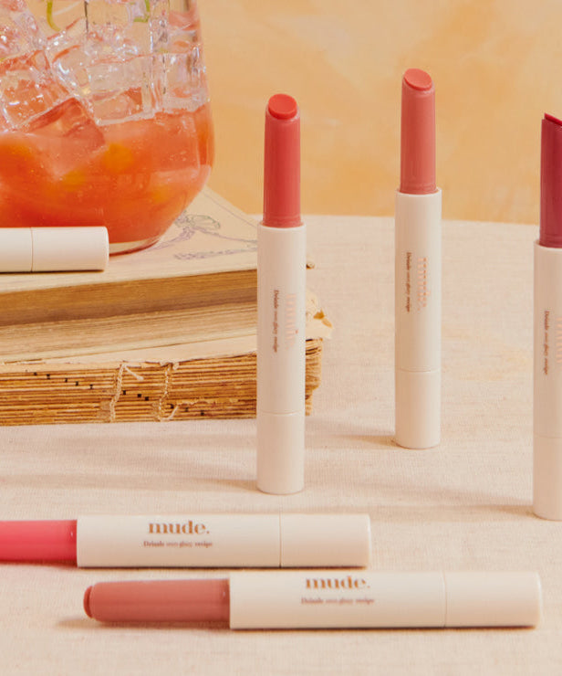 MUDE Drizzle Night lipsticks on display with a cocktail in the background