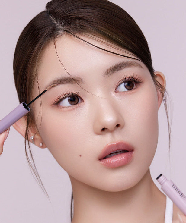 Woman applying MUDE Inspire Skinny Brow Cara for perfect eyebrows.