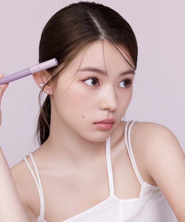 Woman holding MUDE Inspire Skinny Brow Cara for precise eyebrow styling.