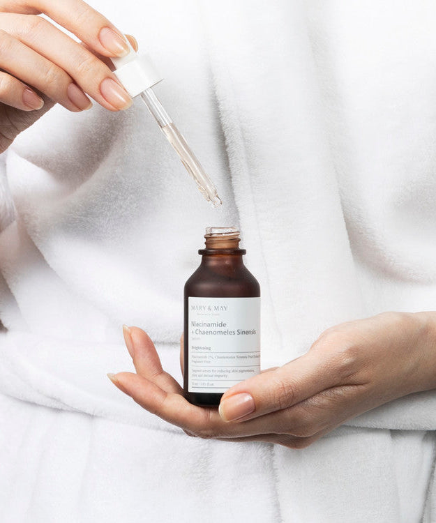 Applying MARY & MAY Niacinamide + Chaenomeless Sinensis Serum 30ml using a dropper