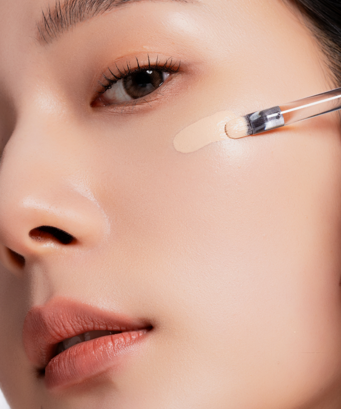 Close-up of applying OIAD Cover Perfecting Mirror Brushed Concealer on skin for flawless finish
