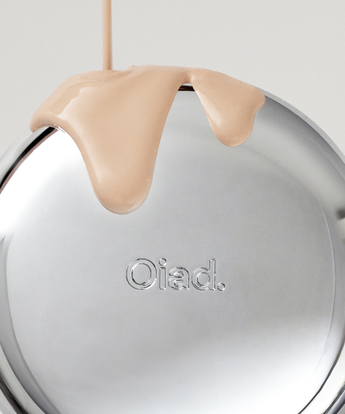OIAD Pore Perfecting Mirror Moon Cushion makeup compact with liquid foundation pouring over the silver surface