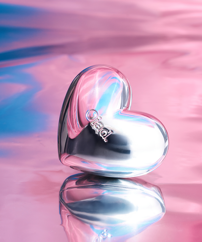 OIAD Silverpulse Moussecream Lip&Cheek in a heart-shaped metallic container with pink and blue background.