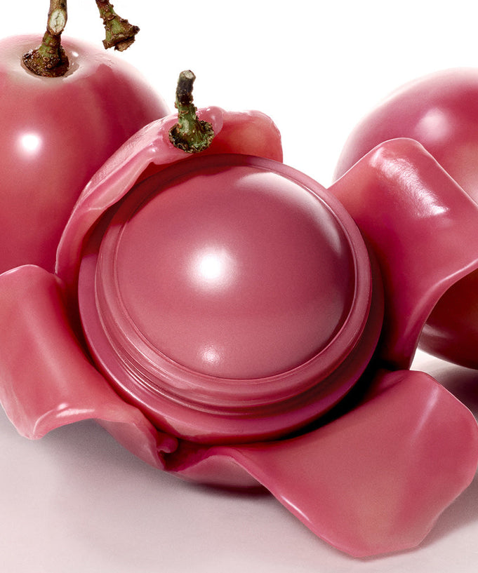 ROMAND Juicy roll cheek with rosy pink hue nestled in vibrant petals