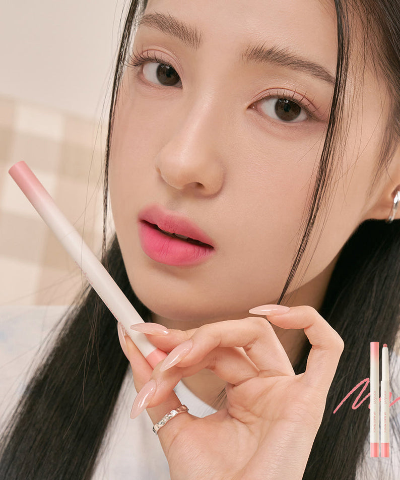 Model holding ROMAND lip mate pencil #beovershade in hand, showcasing its application and color payoff.