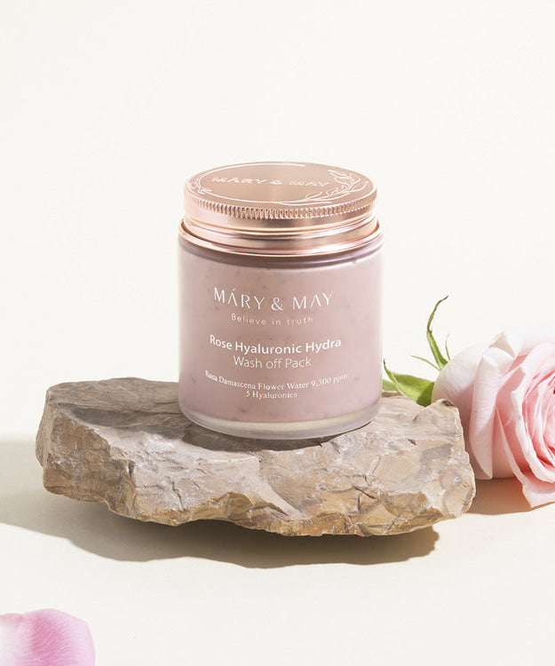MARY & MAY Rose Hyaluronic Hydra Wash off Pack 125g on stone with pink rose beside