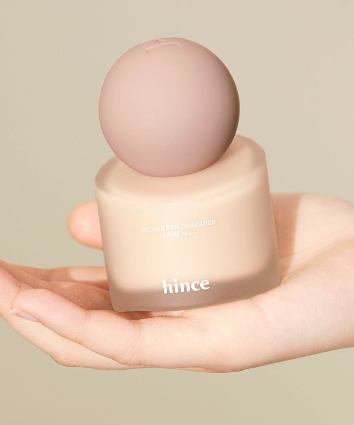 HINCE Second Skin Foundation in hand, showcasing smooth texture and elegant packaging.