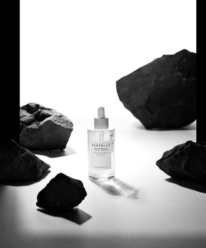 SKIN1004 Madagascar Centella Tone Brightening Capsule Ampoule 100ml bottle surrounded by rocks on a white background