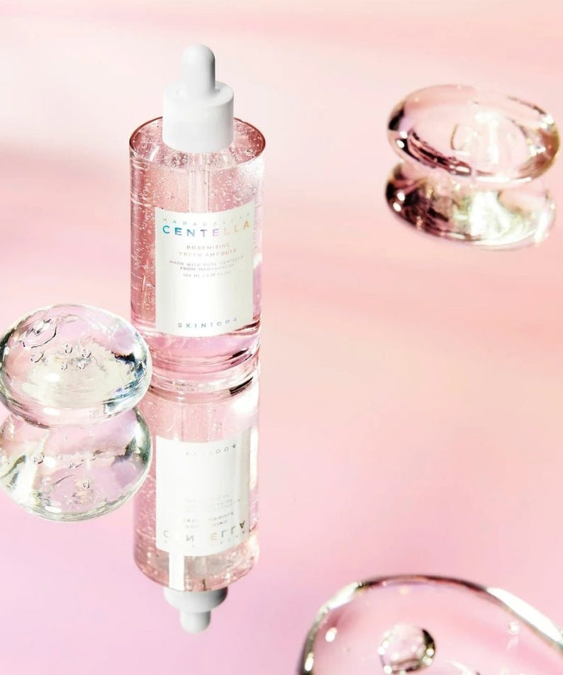 SKIN1004 Madagascar Centella Pore-Mfying Fresh Ampoule 100ml displayed with glass bubbles on a reflective pink surface
