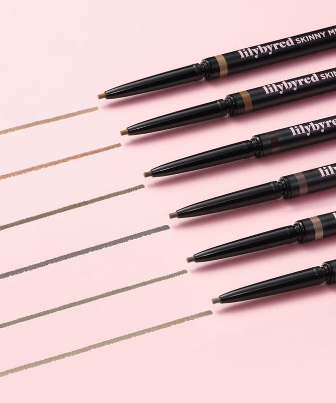LILYBYRED Skinny Mes Brow Pencil with various shades on a pink background, perfect for precise eyebrow definition.