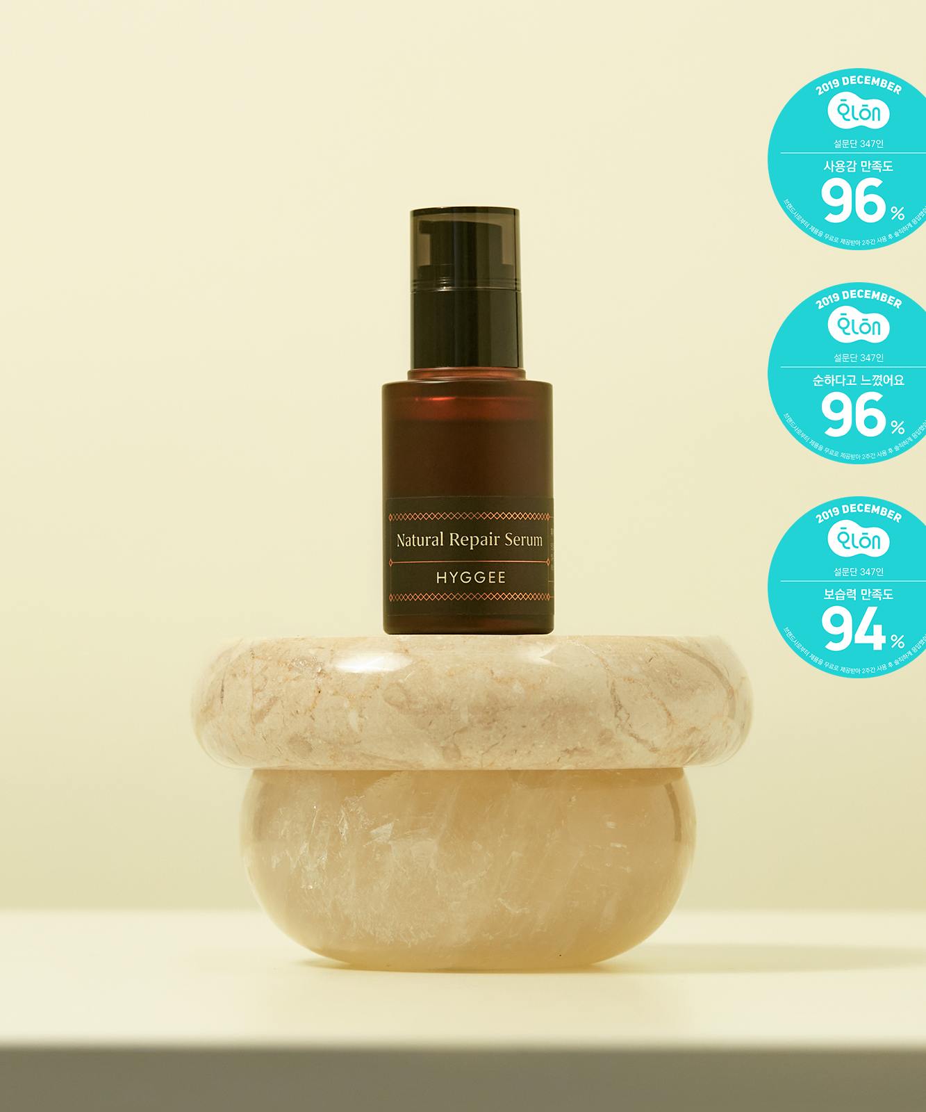 HYGGEE Natural Repair Serum 30ml bottle displayed on a marble stand with quality assurance labels, highlighting the product's features.