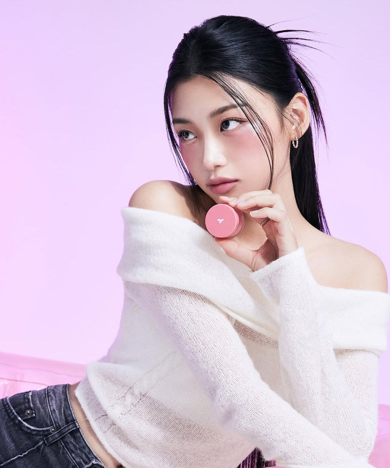 Model holding TONY MOLY Cheek Tone Lip & Cheek Duo Balm against pink background