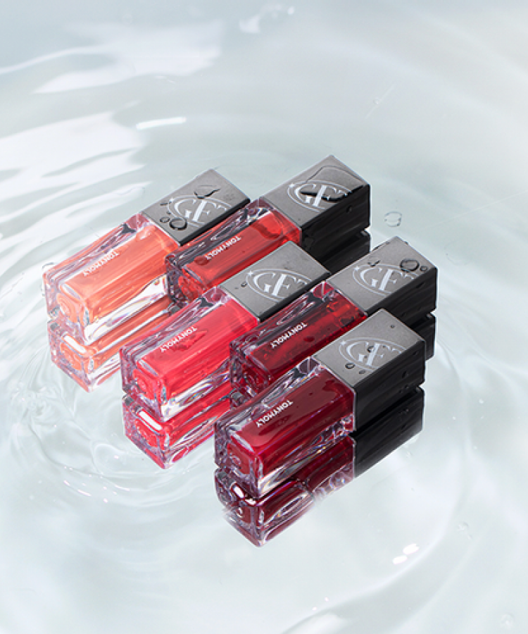 Group of TONY MOLY Get It Tint Colorful Water lip tints floating on water surface, featuring vibrant shades and glossy packages.