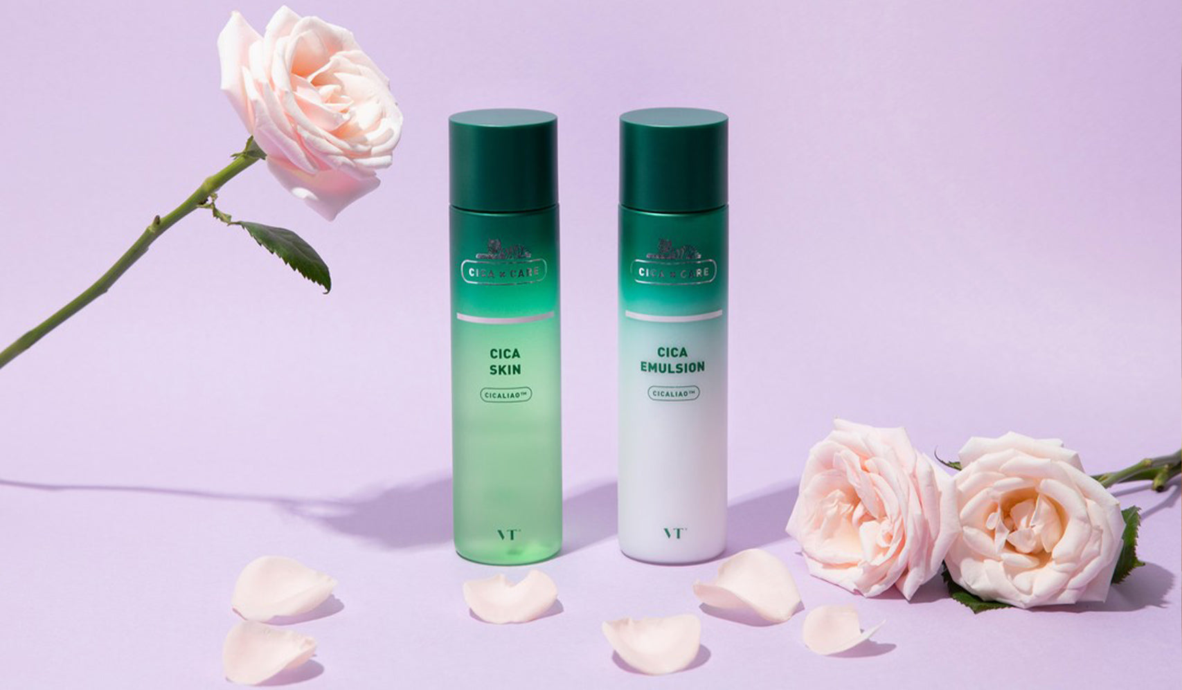 Two bottles of Cica skincare products against a lavender background surrounded by pink roses and petals.