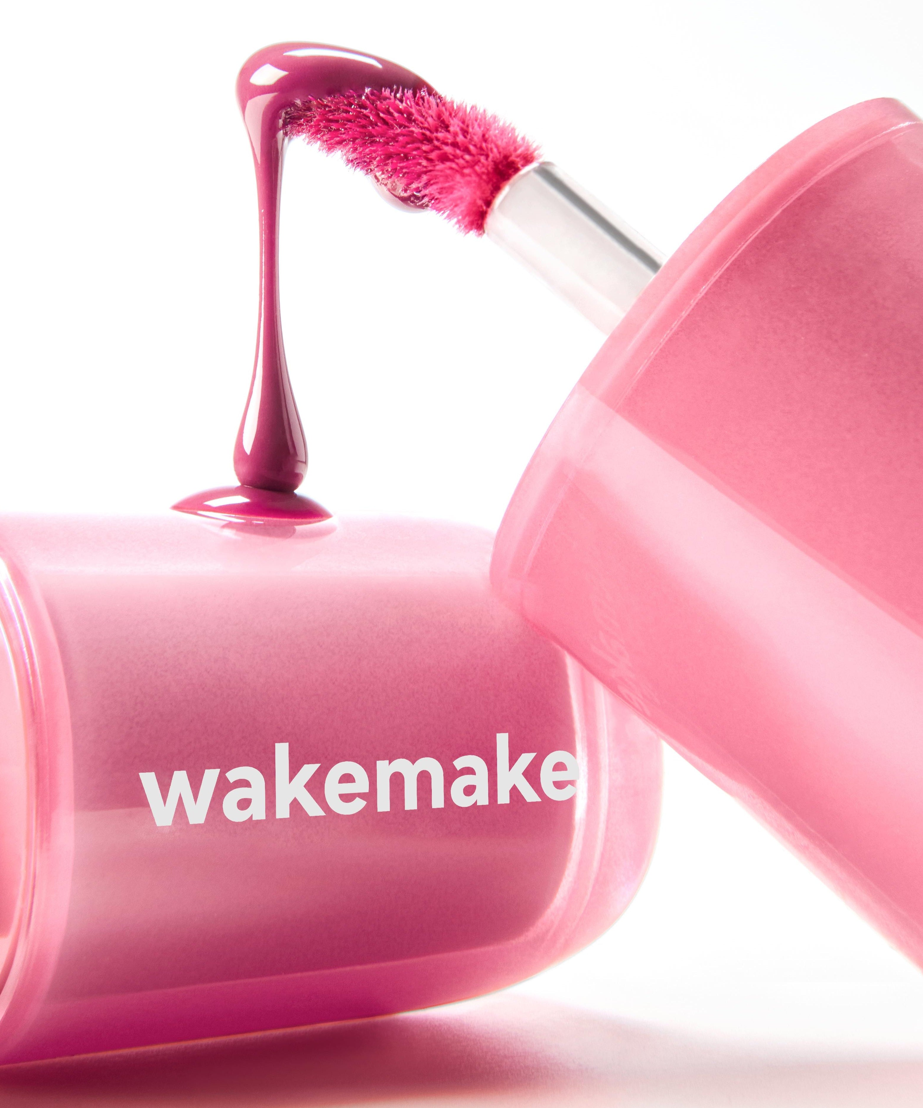 WAKE MAKE Waterfull Glow Tint 4.6g in vibrant pink shade with applicator on display.
