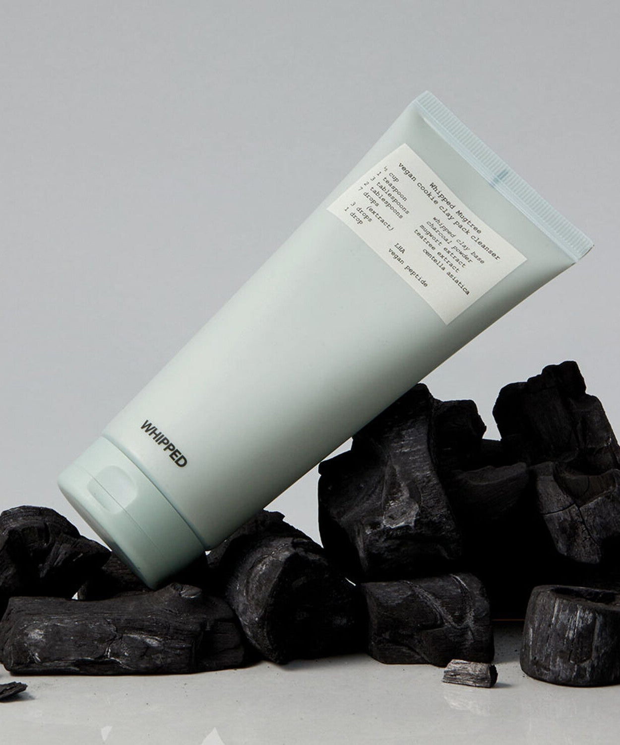WHIPPED Mugtree Vegan Cookie Clay Pack Cleanser 180ml product on display with charcoal background.